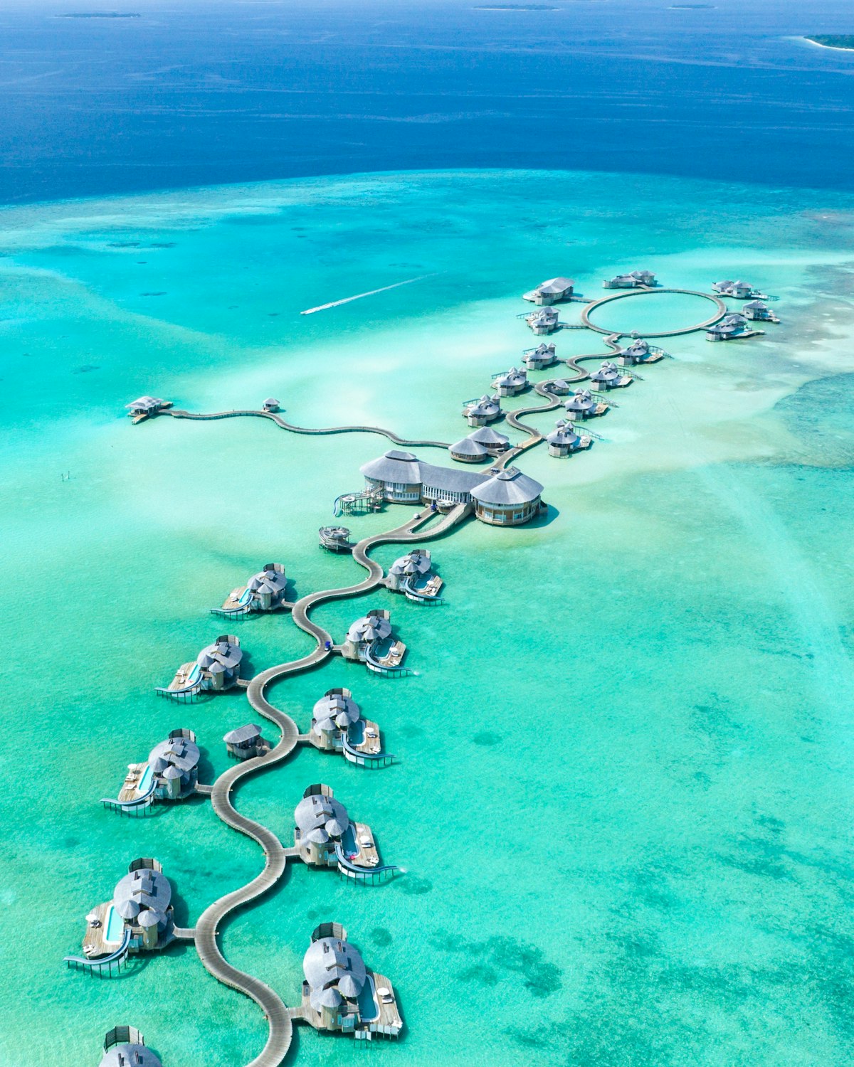 Aerial view of an island resort and overwater villas in the Maldives